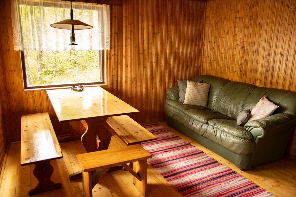Kankijärven mökin rantasauna sisälltä. Saunalla pirtinpöytä ja nahkasohva.