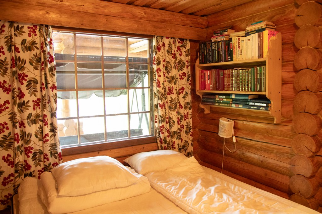 Makuuhuone, jossa parisänky. Seinällä kirjahylly täynnä kirjoja.