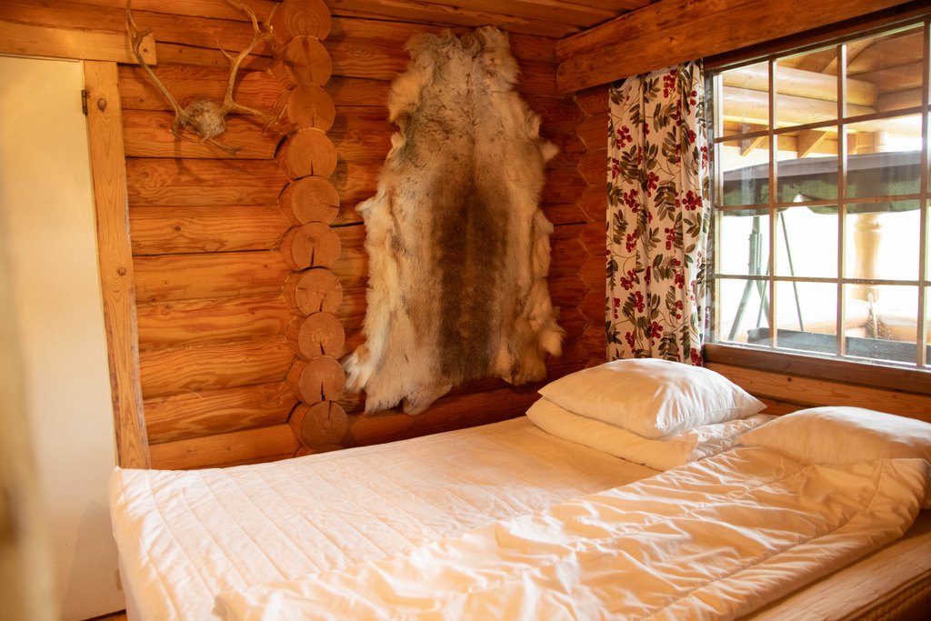 Makuuhuone, jossa parisänky. Seinällä poron talja ja sarvet.
