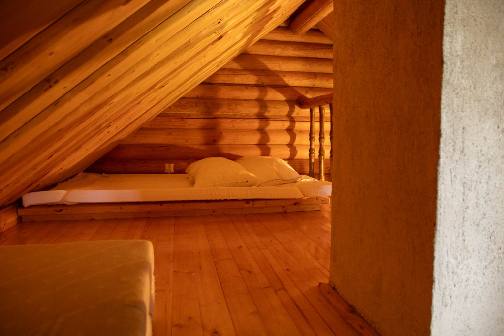Mökin parvi, jossa patjoja, tyynyjä ja peittoja. Katto on matala.