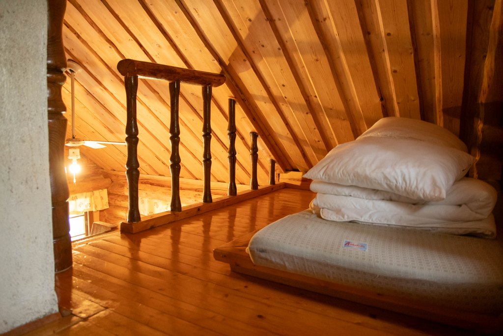 Mökin parvi, jossa patjoja, tyynyjä ja peittoja. Katto on matala.